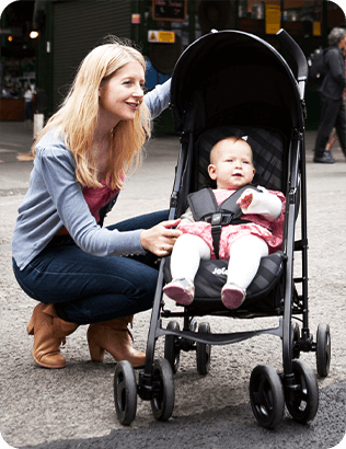 The mother crouched next to the baby in the Joie Nitro stroller