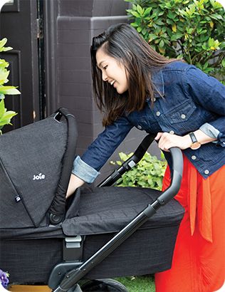 Mother teasing her baby in the chrome™ dlx and carry cot