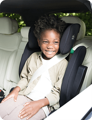 Enfant assis dans un rehausseur à dossier haut i-Traver noir de Joie, attaché en toute sécurité dans la voiture.