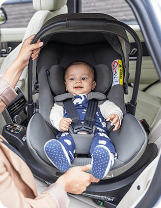 Miminko se usmívá v autosedačce Joie i-Level Pro uvnitř auta.