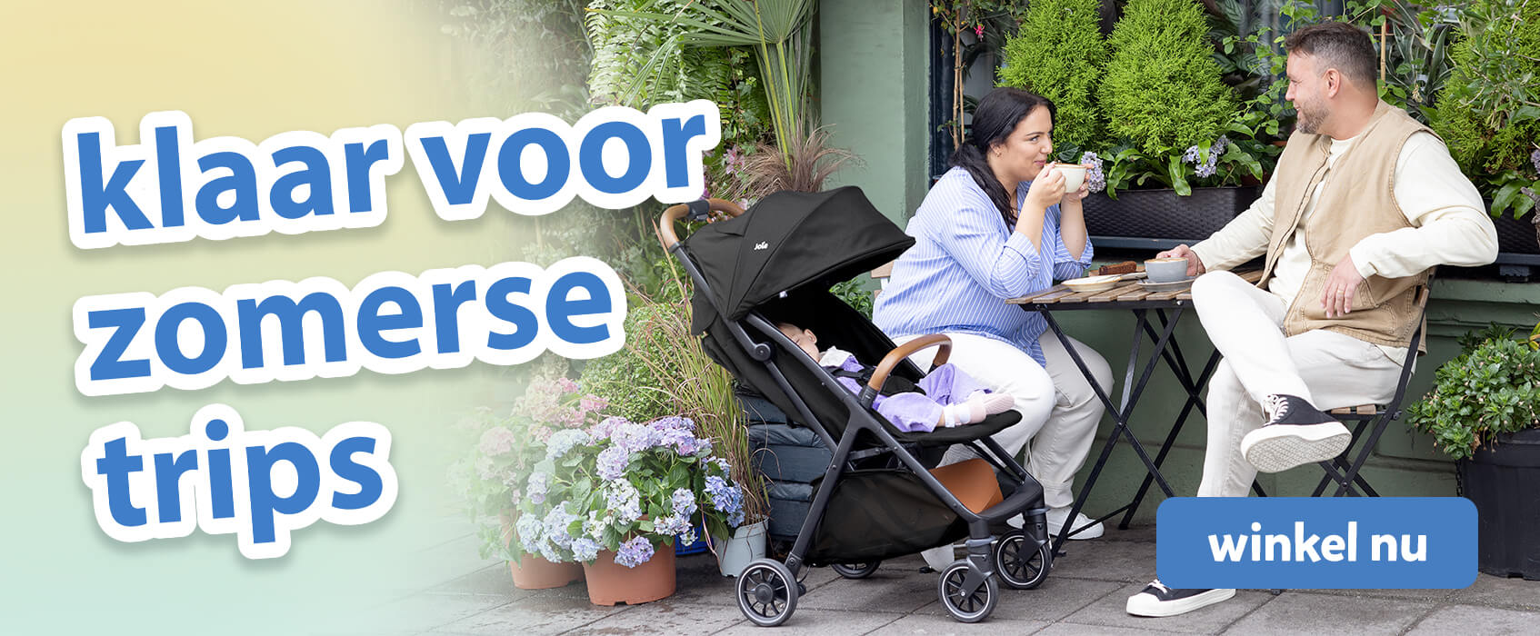 Ouders zitten te kletsen met een kop koffie aan een caf&eacute;tafel in een tuinsetting buiten. De baby ligt er comfortabel naast in de Joie pact pro kinderwagen. Tekst op de afbeelding benadrukt de must-haves voor zomerse uitstapjes.